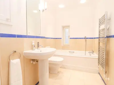 a bathroom with a sink and a toilet and a tub at 9 Church Farm Rise in Aldeburgh