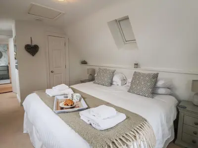 a bedroom with two beds with towels and a tray of food at 9 Church Farm Rise in Aldeburgh