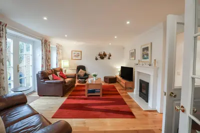 a living room with a couch and a fireplace at 9 Church Farm Rise in Aldeburgh