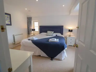 a bedroom with a bed with a blue blanket on it at 9 Church Farm Rise in Aldeburgh