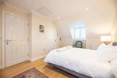 a bedroom with a large white bed and a window at Fromus Rise, Saxmundham in Saxmundham