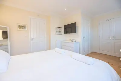 a white bedroom with a large white bed at Fromus Rise, Saxmundham in Saxmundham