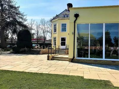 a yellow house with large windows on the side of it at Best Western Priory Hotel in Bury Saint Edmunds