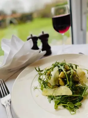 a white plate with a salad and a glass of wine at Best Western Priory Hotel in Bury Saint Edmunds