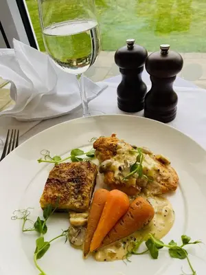 a plate of food with meat and vegetables and a glass of wine at Best Western Priory Hotel in Bury Saint Edmunds