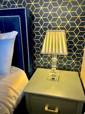 a lamp on a table next to a bed at Honey Hill Cottage - 4 Bedroom Detached House in Cambridge