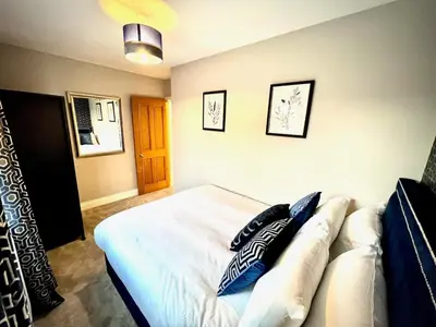 a bedroom with a white bed with pillows on it at Honey Hill Cottage - 4 Bedroom Detached House in Cambridge