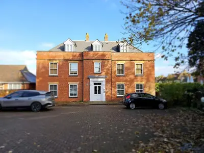 a large brick building with a car parked in front of it at Eaglegate in Colchester