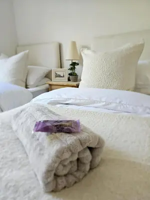 a white bed with a blanket and a purple object on it at Eaglegate in Colchester