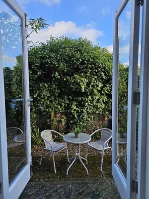a patio with a table and chairs and a glass door at Eaglegate in Colchester