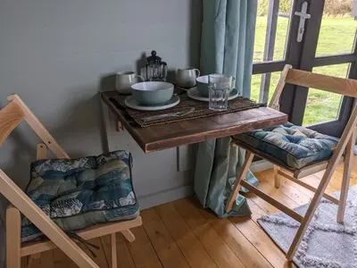 a table with bowls and plates on top of it at Blue Sky Huts in Chediston