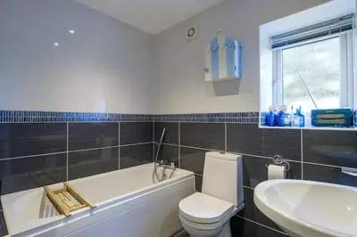 a bathroom with a tub and a toilet and a sink at Fishermans Loft - A seaside house in Thorpeness with direct access to the beach - Aldeburgh Coastal Cottages in Thorpeness