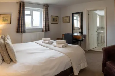 a bedroom with a large white bed with towels on it at Fishermans Loft - A seaside house in Thorpeness with direct access to the beach - Aldeburgh Coastal Cottages in Thorpeness