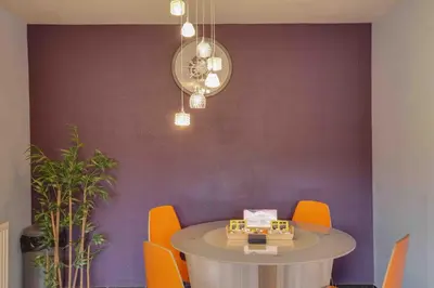 a dining room with a table and orange chairs at Blackwater Terrace Witham in Faulkbourne