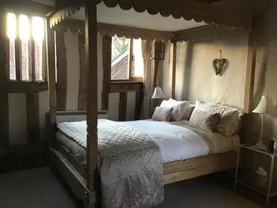 a bedroom with a canopy bed with white sheets and pillows at Valley Farmhouse, Westhall in Southwold