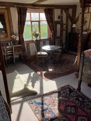 a living room with a table and a window at Valley Farmhouse, Westhall in Southwold