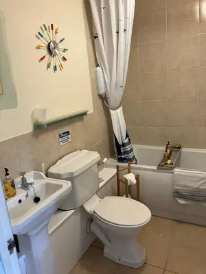 a bathroom with a toilet and a sink and a tub at Valley Farmhouse, Westhall in Southwold