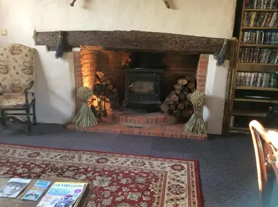 a living room with a brick fireplace with a fire place at Valley Farmhouse, Westhall in Southwold