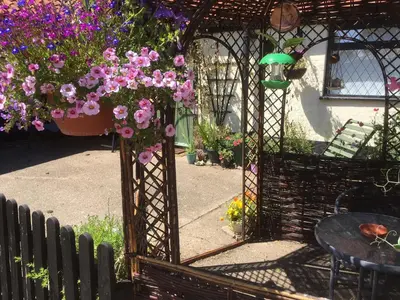 a garden with a gazebo with a bunch of flowers at Valley Farmhouse, Westhall in Southwold