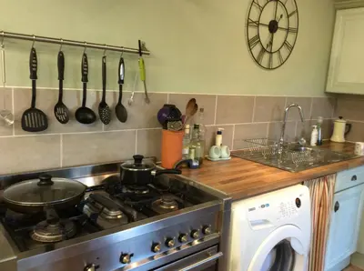 a kitchen with a stove and a stove top oven at Valley Farmhouse, Westhall in Southwold