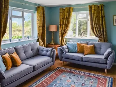 a living room with two couches and two windows at Heath View in Saxmundham