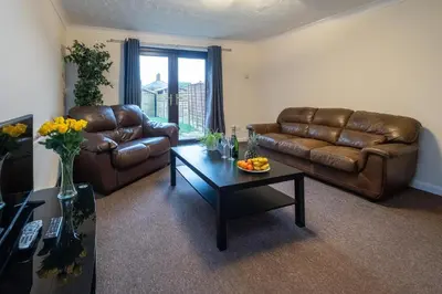 a living room with two leather couches and a coffee table at 52 Carr Avenue in Leiston