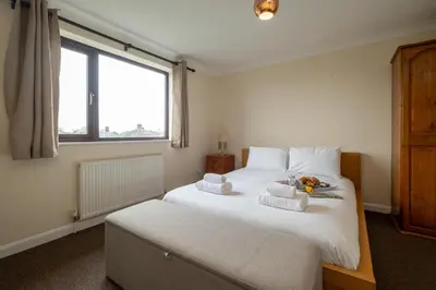 a bedroom with a bed with towels on it at 52 Carr Avenue in Leiston
