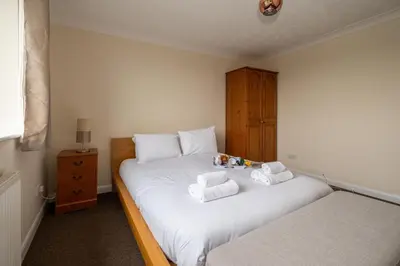 a bedroom with two twin beds with towels on them at 52 Carr Avenue in Leiston