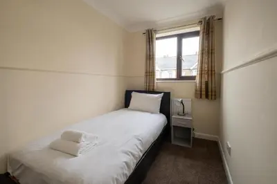 a small bedroom with a bed and a window at 52 Carr Avenue in Leiston