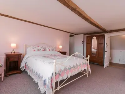 a bedroom with a white bed and two night stands at West House Farm in Leiston