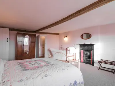 a bedroom with a bed and a fireplace at West House Farm in Leiston