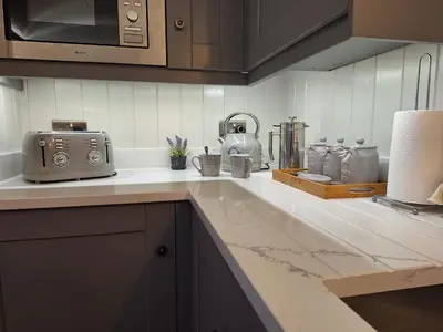 a kitchen with a counter with a toaster and appliances at Whiskers and Woods Shepherd Hut in Denham