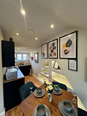 a dining room with a table and a kitchen at Central Cambridge Apartments by Tas in Cambridge