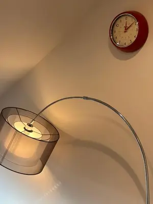 a lamp with a clock on a wall next to a clock at Central Cambridge Apartments by Tas in Cambridge