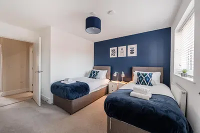 two beds in a bedroom with blue walls at 4 Bed, 3 Bath in Colchester - Business, Contractor and Leisure - Singles or Superkings - Disc0unts in Colchester