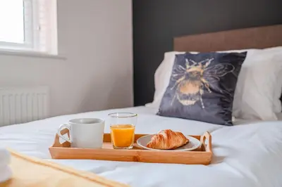 a tray with a breakfast of orange juice and croissants at 4 Bed, 3 Bath in Colchester - Business, Contractor and Leisure - Singles or Superkings - Disc0unts in Colchester