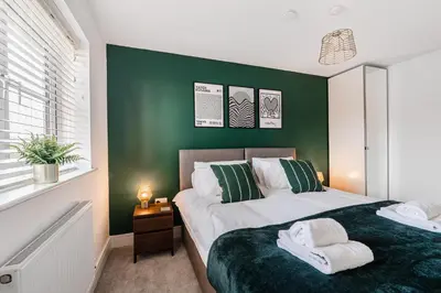 a bedroom with two beds and a green wall at 4 Bed, 3 Bath in Colchester - Business, Contractor and Leisure - Singles or Superkings - Disc0unts in Colchester