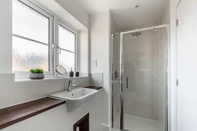 a white bathroom with a sink and a shower at 4 Bed, 3 Bath in Colchester - Business, Contractor and Leisure - Singles or Superkings - Disc0unts in Colchester