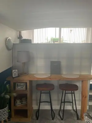 a wooden table with two stools in a room at Judith Barge in Colchester