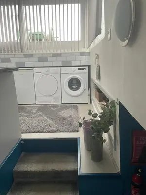 a laundry room with a washing machine and a window at Judith Barge in Colchester