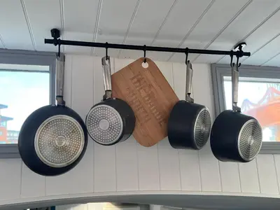 a group of pots and pans hanging from a wall at Judith Barge in Colchester