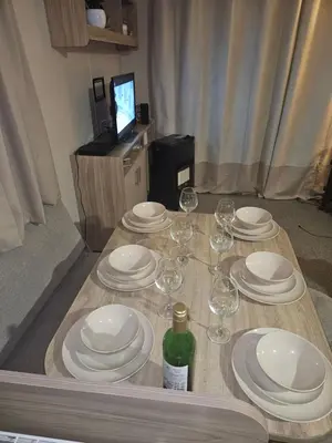 a table with white plates and wine glasses on it at Jenny,s place in Saint Osyth