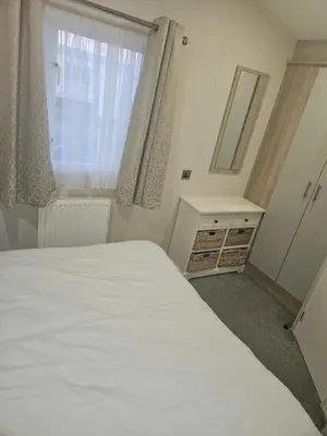 a bedroom with a white bed and a window at Jenny,s place in Saint Osyth