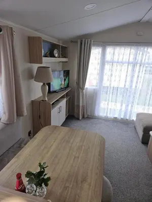 a living room with a table and a tv at Jenny,s place in Saint Osyth