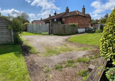 a yard with a fence and a house at Love Heart Cottage in Wickham Market