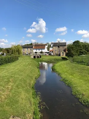 a river in a field with houses in the background at Love Heart Cottage in Wickham Market