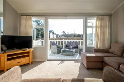 a living room with a television and a couch at Sea La Vie in Sizewell