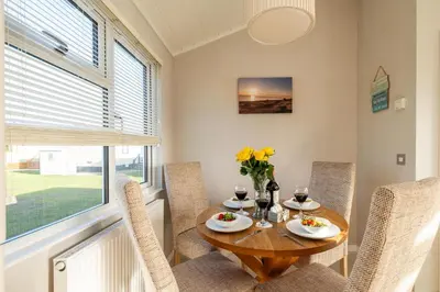 a dining room with a table and chairs and a window at Sea La Vie in Sizewell
