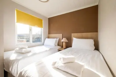 two white beds in a room with a window at Sea La Vie in Sizewell