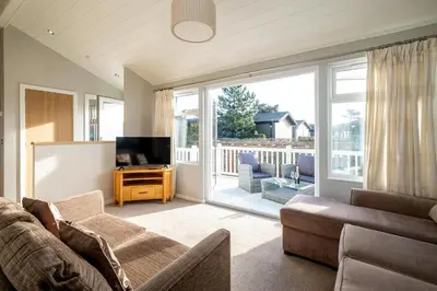 a living room with a couch and a television at Sea La Vie in Sizewell